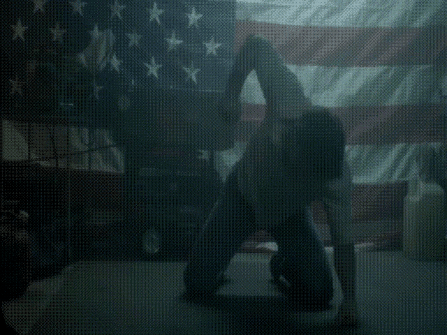a blurred image of a person standing in front of a large american flag