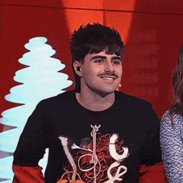 a man with a mustache wears a black shirt that says you