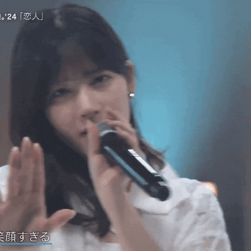 a woman singing into a microphone with the number 24 visible in the corner