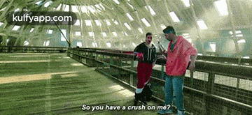 a man is standing next to another man on a bridge .