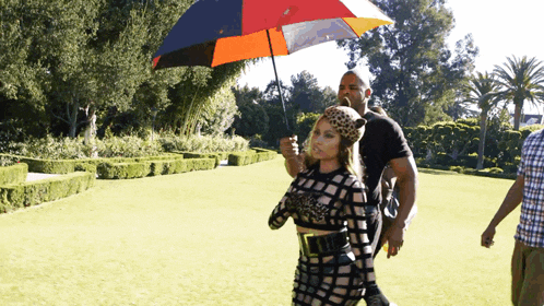 a woman holding an umbrella in a park with trees in the background
