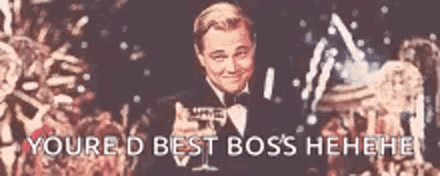 a man in a tuxedo is holding a glass of wine and toasting .