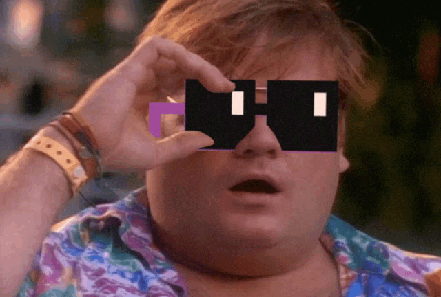 a man wearing sunglasses that have a purple stripe on the bottom