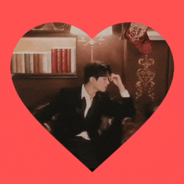 a man in a suit is sitting inside of a heart