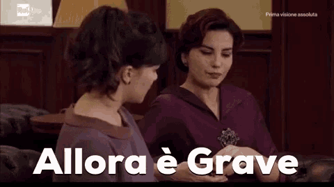 two women are sitting next to each other with the words " allora e grave " on the screen