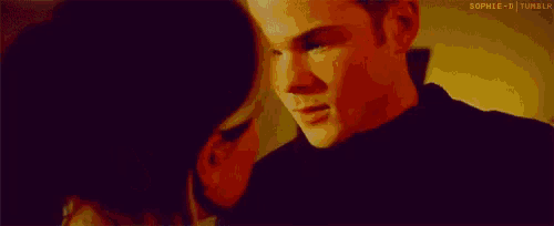 a man and a woman are kissing each other in a room .
