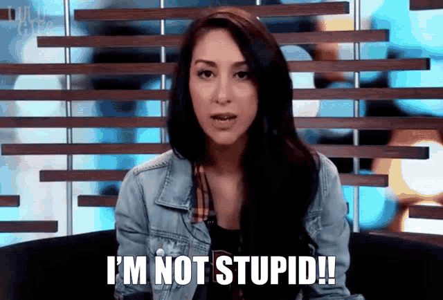 a woman in a denim jacket is saying i 'm not stupid !