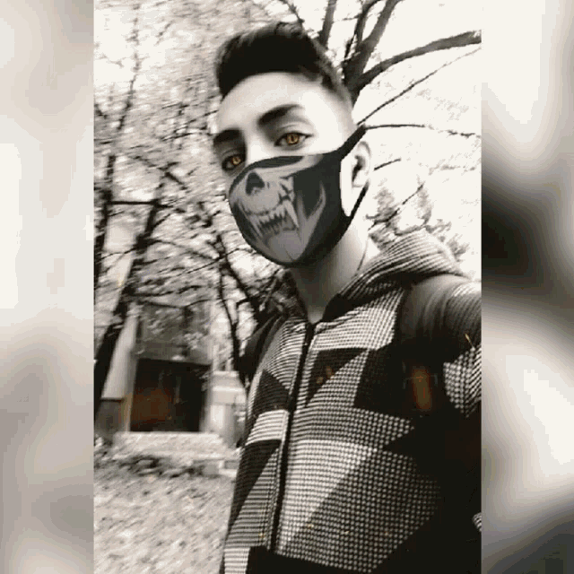 a young man wearing a face mask with a skull design on it
