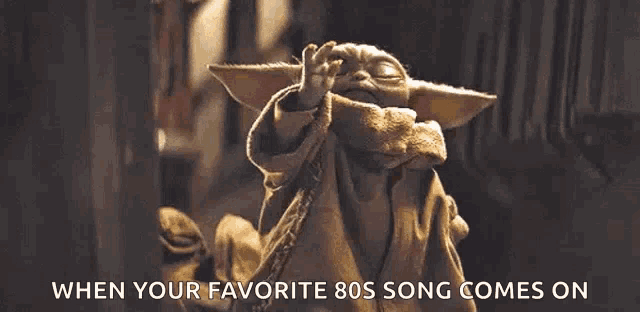 a baby yoda from star wars is waving his hand and says when your favorite 80s song comes on