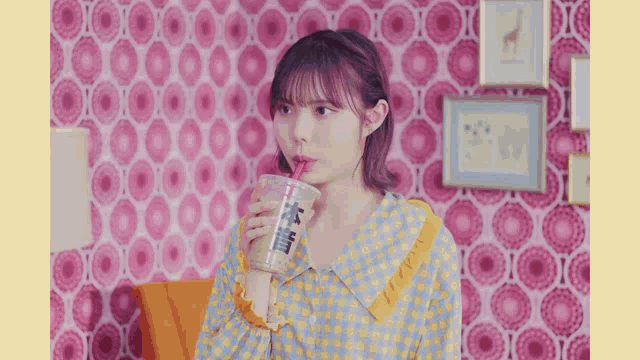 a woman drinking from a cup with a straw