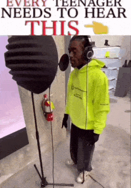 a man in a neon yellow hoodie is standing in front of a microphone with headphones on .