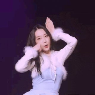 a woman in a blue dress and white fur coat is dancing on a stage .