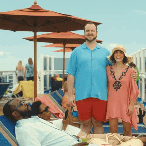 a man in a blue shirt and red shorts is standing next to a woman in a pink dress