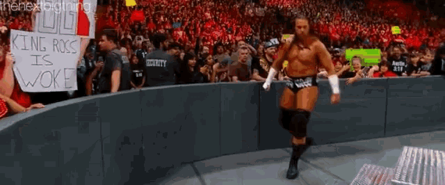 a man in a wrestling ring with a sign that says king ross is woke