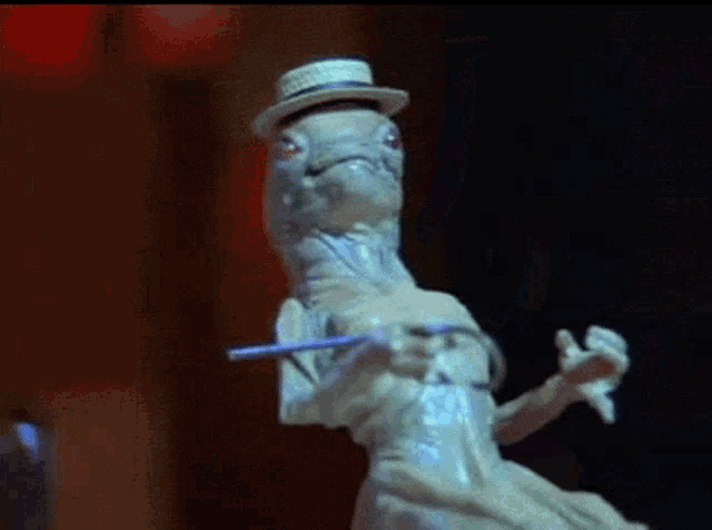 a statue of a lizard wearing a hat and holding a toothbrush