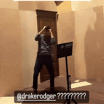 a man standing in a room with a sign that says slime