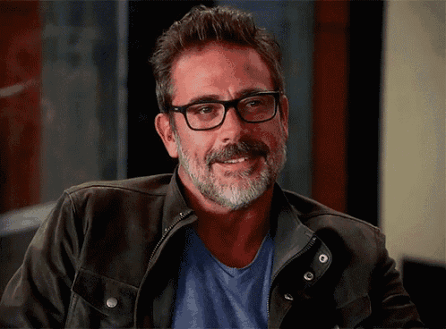 a man with glasses and a beard wearing a leather jacket