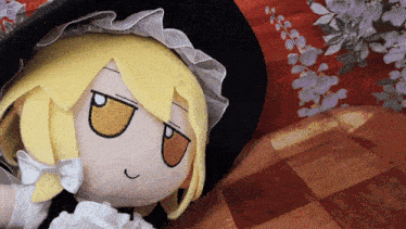 a stuffed doll with a yellow hair and a black hat