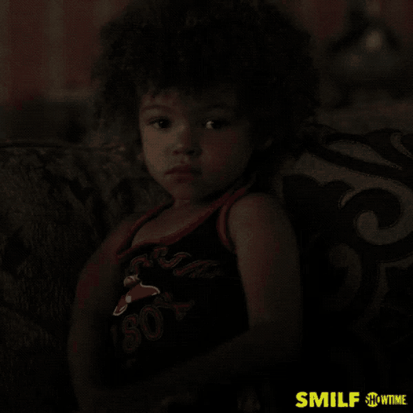 a little girl is sitting on a couch wearing a shirt that says sox