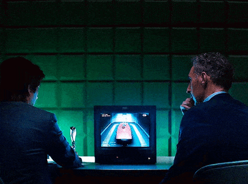 a man and a woman sit in front of a computer monitor that says lg on it
