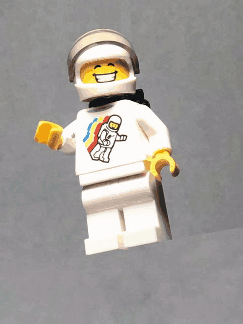 a lego figure wearing a helmet and a rainbow shirt with an astronaut on it