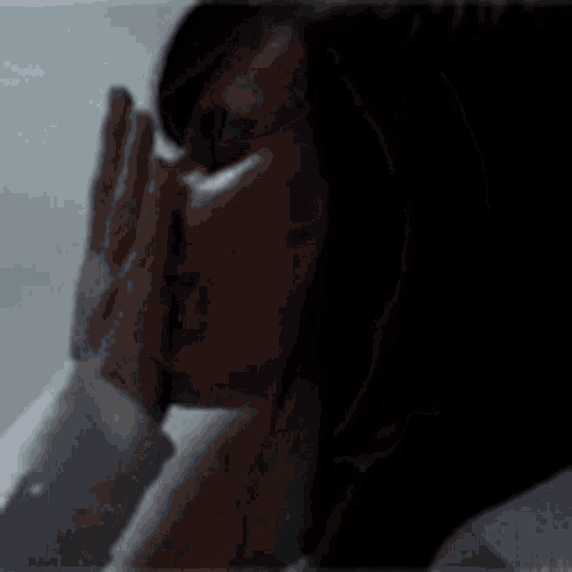 a close up of a woman 's face in a dark room with a blurry background .