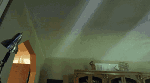 a room with a lamp and a statue of a ship on the wall