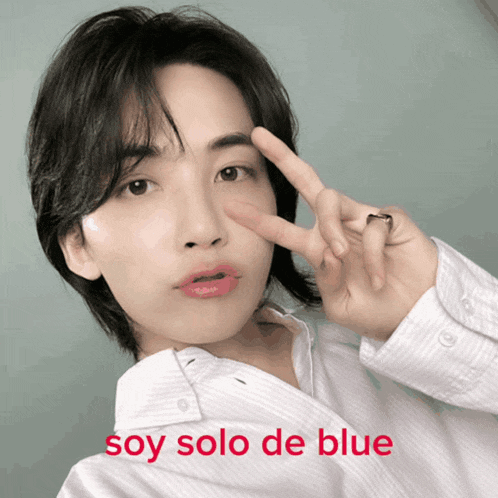 a young man giving a peace sign with the words soy solo de blue written below him