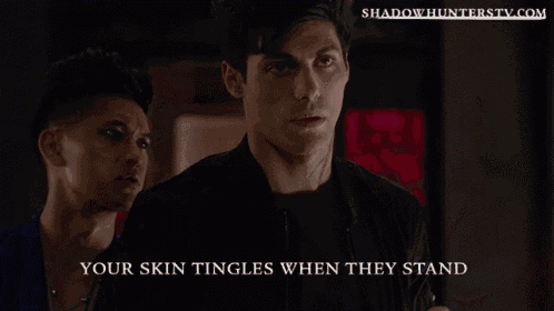 a man and a woman are looking at each other with the website shadowhunterstv.com in the background
