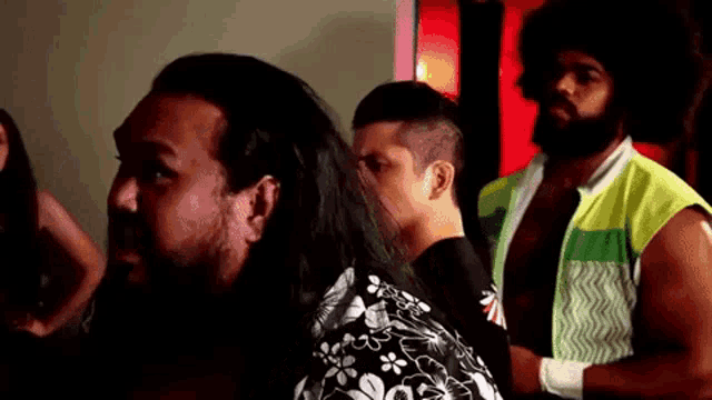 a group of wrestlers are standing in a room .