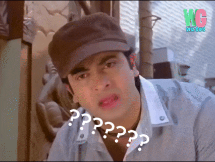 a man wearing a hat and a gray shirt is making a funny face with a question mark on his face