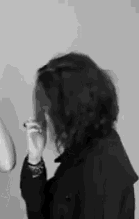 a black and white photo of a woman covering her face .