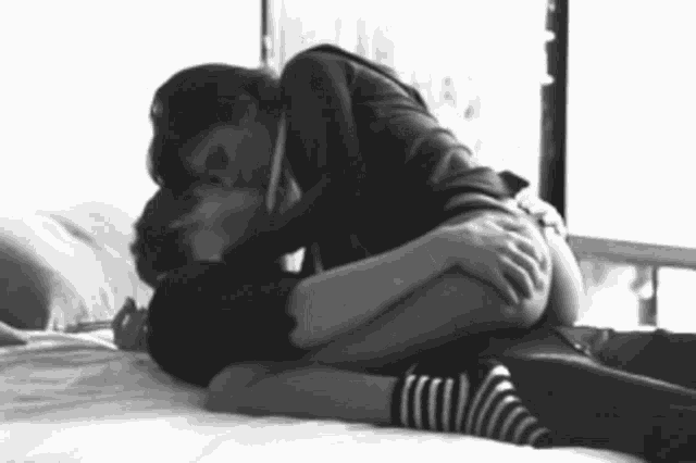 a black and white photo of a man and woman kissing