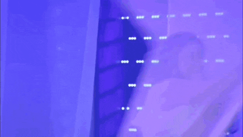 a woman in a blue saree is standing in front of a blue light and giving a thumbs up .