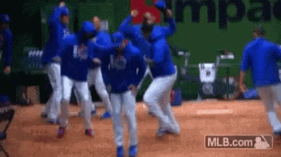 a group of baseball players are dancing on a field in front of a mlb.com logo .