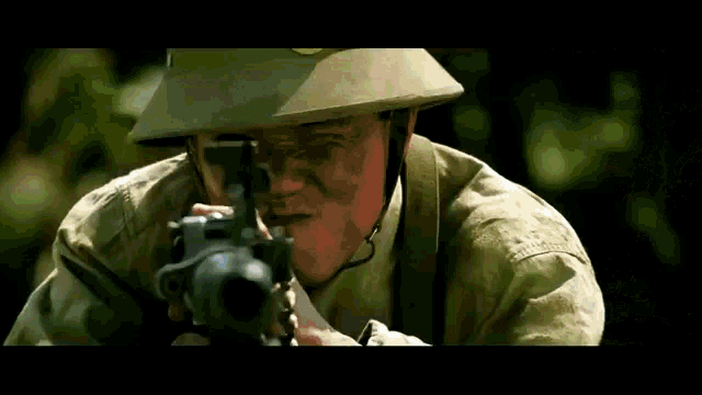 a soldier wearing a helmet is aiming a gun