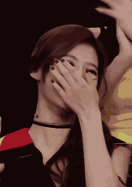 a woman is covering her mouth with her hand while wearing a choker .