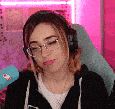 a woman wearing headphones and glasses has a sticker on her shirt that says ' coca-cola '
