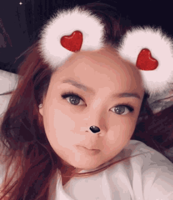 a woman wearing a furry headband with two red hearts on it