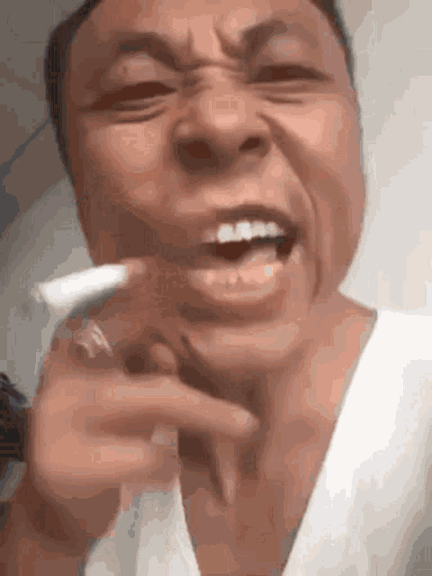 a close up of a man smoking a cigarette with his mouth open
