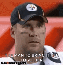 a man wearing a hat and a white shirt is sitting in a stadium and says the man to bring it all together .