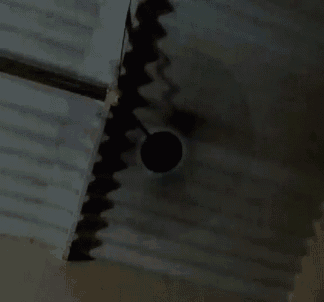 a ceiling fan is hanging from the ceiling of a room with stairs .