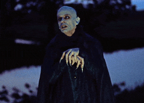 a man in a black cape has a claw on his arm that says ' 666 '