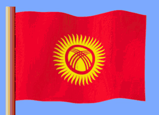 a red flag with a yellow sun in the middle is waving in the wind