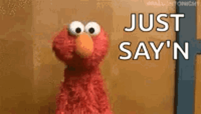 elmo from sesame street is standing in front of a wooden wall and saying `` just say n '' .