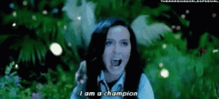a woman is singing i am a champion in front of a green background .