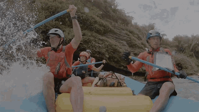 a man wearing an orange shirt that says ' rio ' on it is rowing a raft
