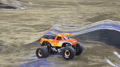 a monster truck is driving down a dirt track