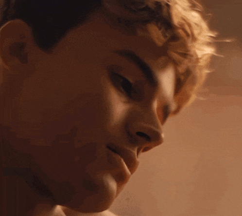 a close up of a young man 's face with his eyes closed and his mouth open