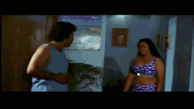 a man and a woman are standing next to each other in a room in a movie .